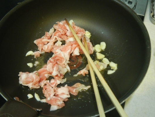 豚肉とニンニクを炒める